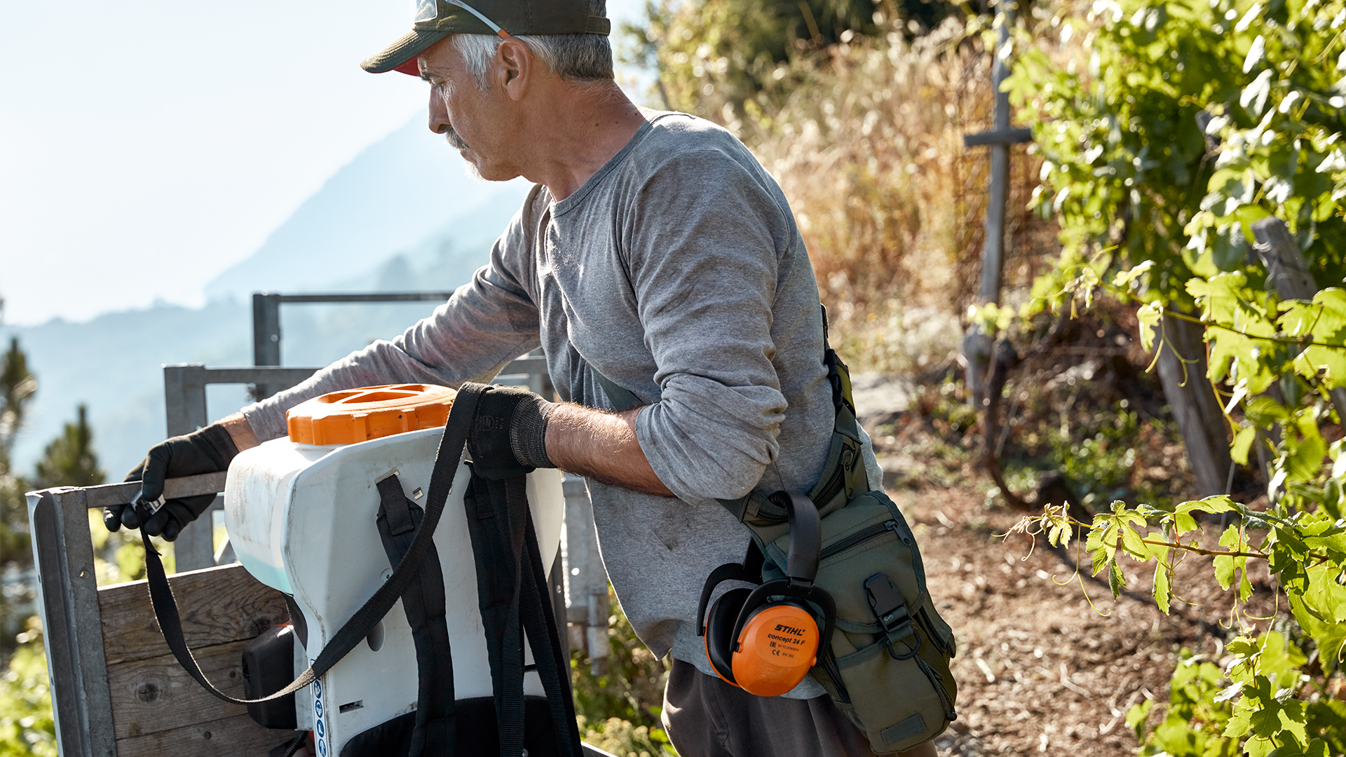 En man lossar STIHL SR 200 bensinspruta och tillbehör i vingården