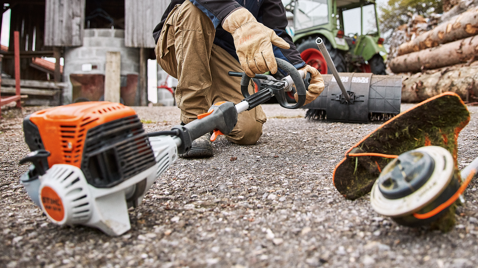 En man med STIHL KombiSystem KM 131 R med tillbehör på en gård
