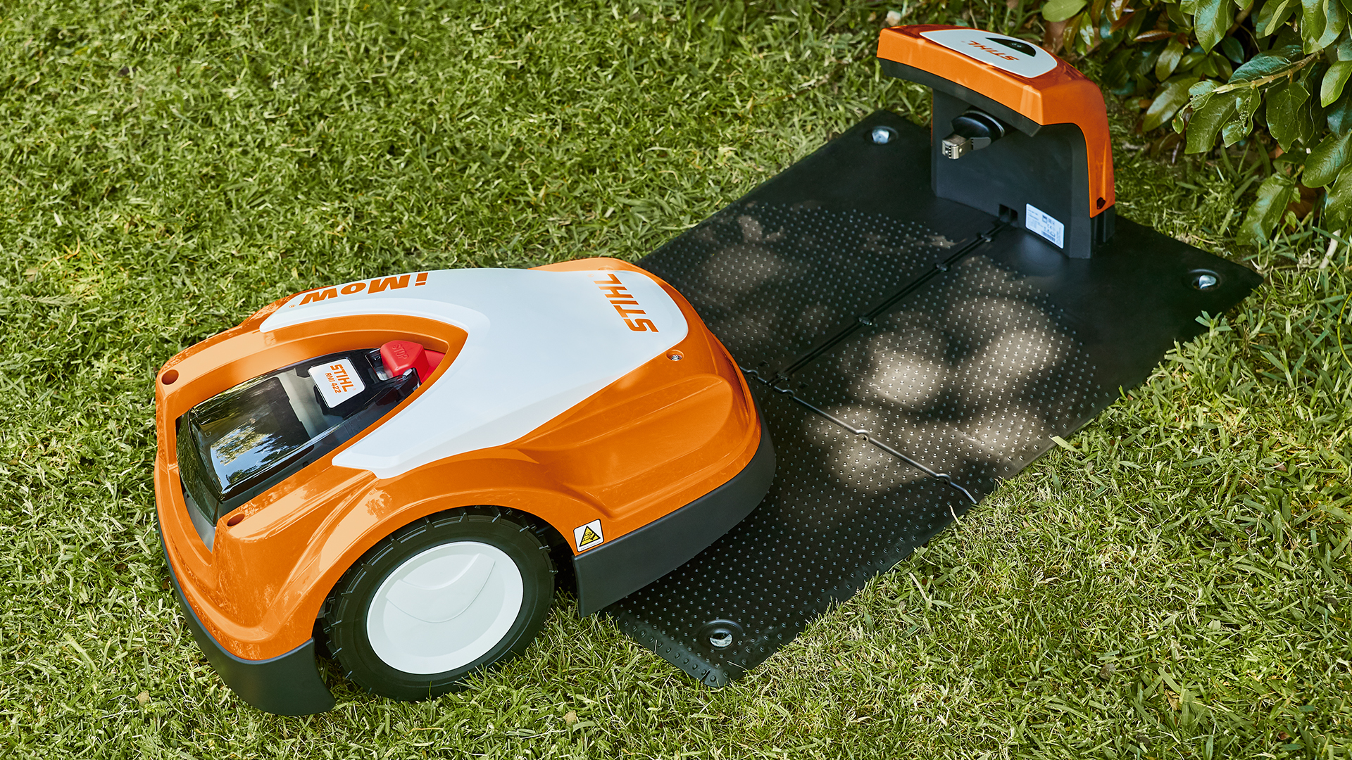 STIHL robotgräsklippare RMI 422 närmar sig STIHL dockningsstation i trädgården