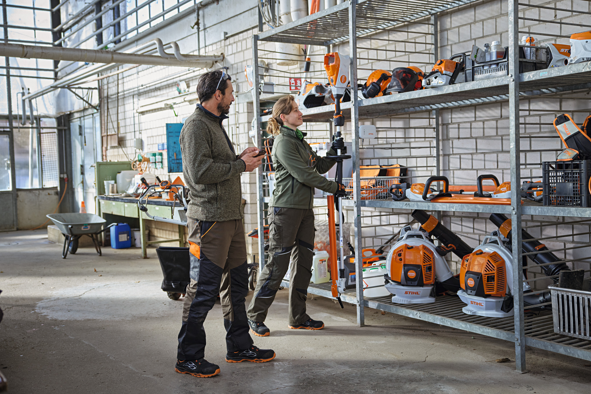 Landskapsarkitekter i ett förråd kontrollerar produktstatus med STIHL connected-appen