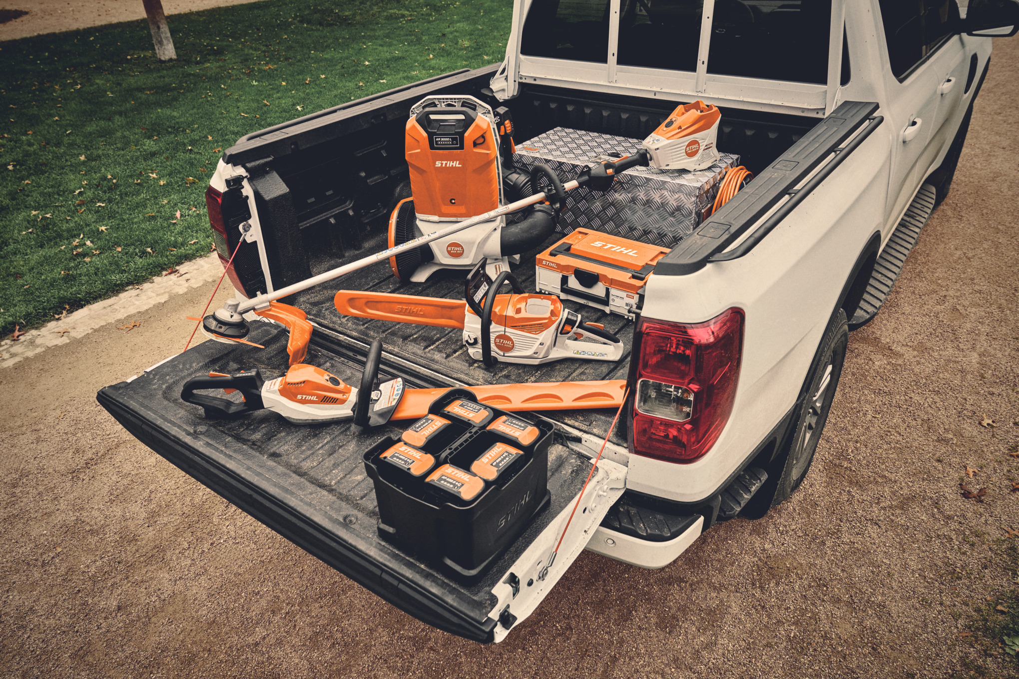 Ett trädgårds- och miljöteam med professionella batteridrivna maskiner från STIHL går längs en gata.