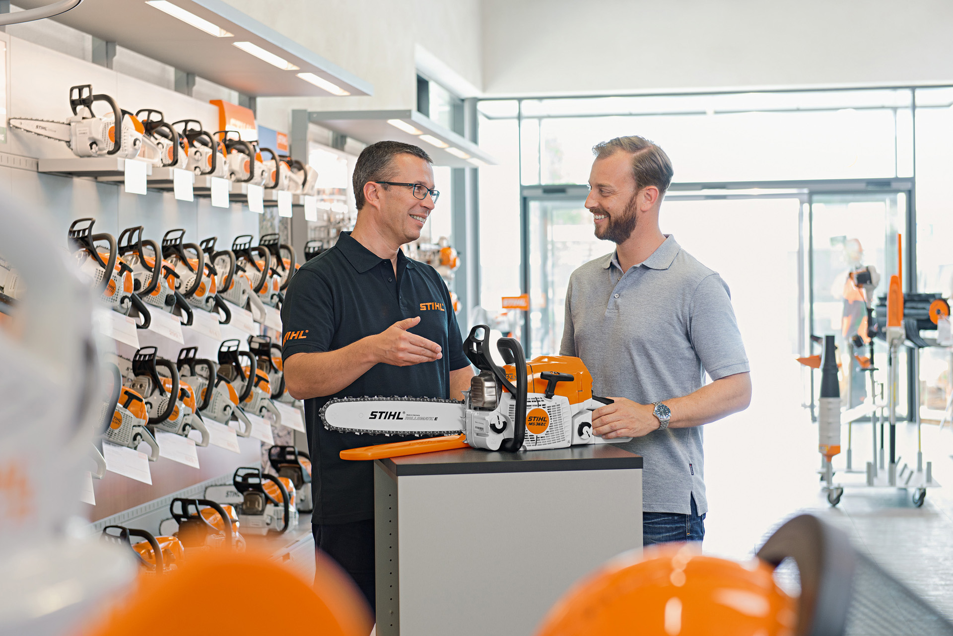 En STIHL-återförsäljare hjälper en kund som köper en STIHL motorsåg