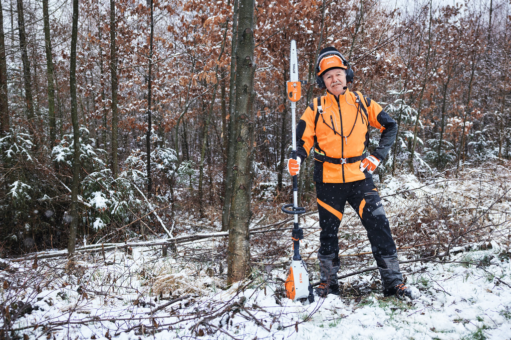 En man med skyddsutrustning kapar en björk med en batteridriven stamkvistare STIHL HTA 150