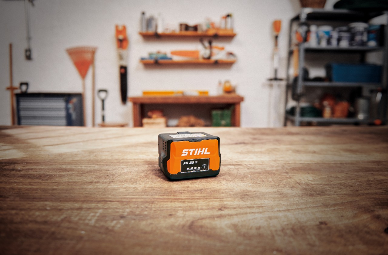 Verkstad med ett STIHL AK 30 S-batteri på ett träbord 