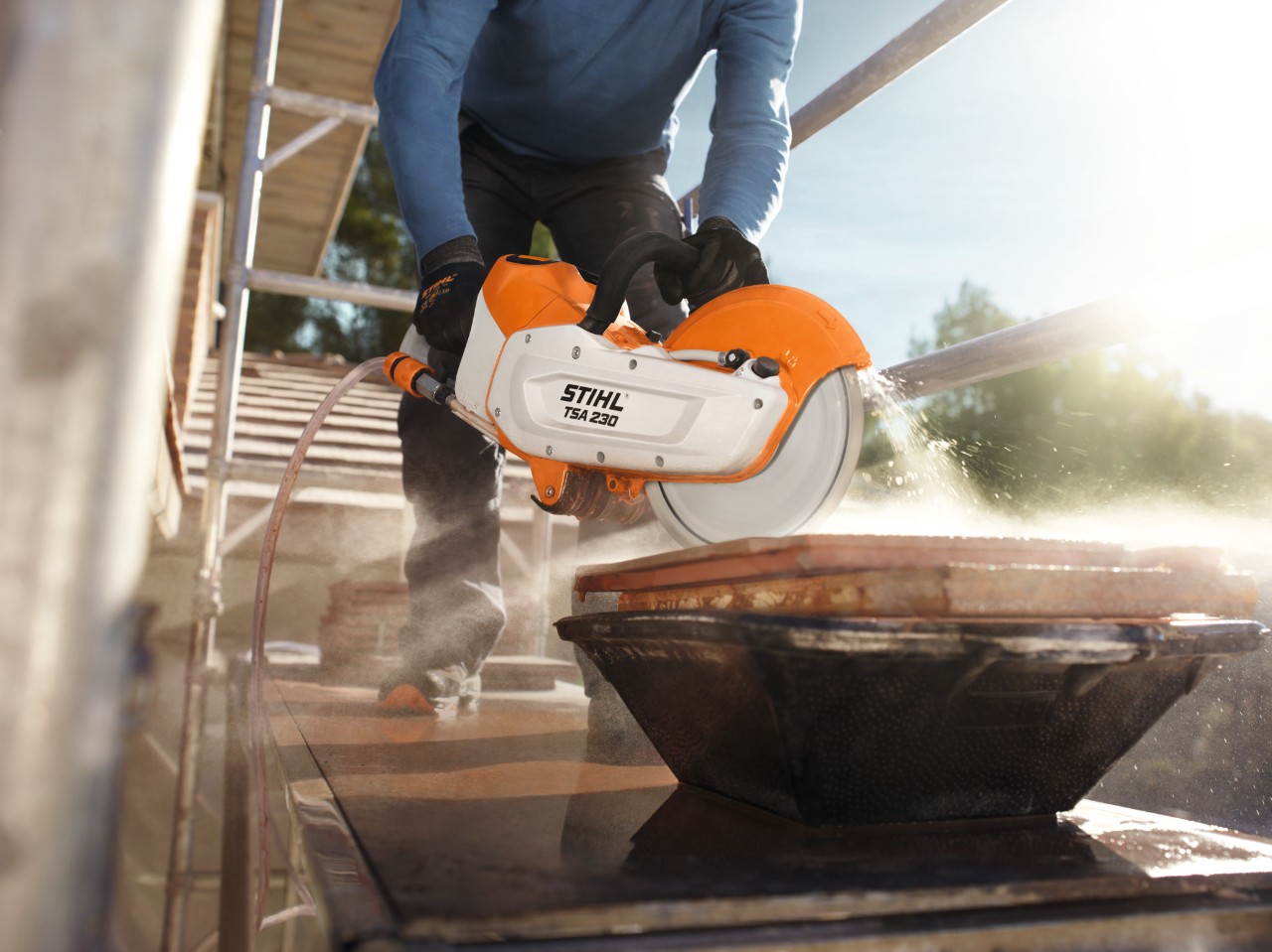 Eine Person arbeitet mit dem Akku-Trennschleifer STIHL TSA 230 auf einem Gerüst