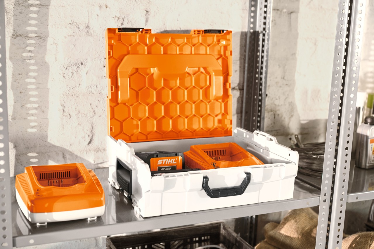 STIHL batteribox med STIHL-batterier på en verkstadshylla  